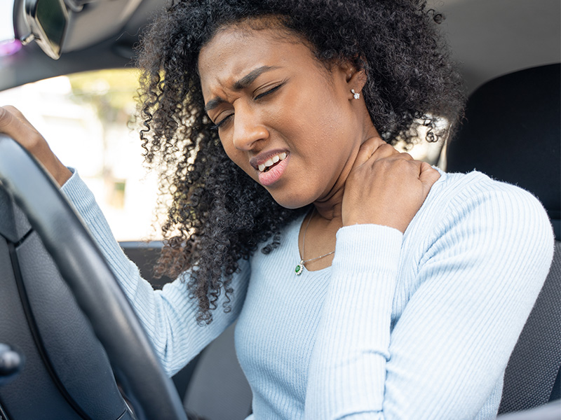 Woman holding neck in pain from car accident